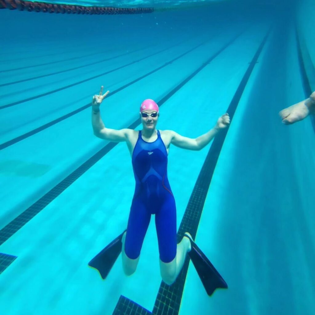 Raquel mergulhando na piscina olímpica imagem relacionada ao texto sobre esporte e câncer de mama